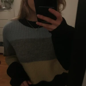 Stickad tröja  - Säljer en stickad tröja med gråa, svarta, gula och blåa ränder från NA-KD. Jätte skön och fin men kommer inte till användning. Buda gärna! 💕