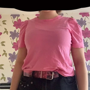 En rosa tröja - Det här är en rosa T-shirt från MONKL och den är oanvänd. Tyget är ganska tunt och den är väldigt strechig. Den här T- shirten har jag haft i 2 år men som sagt så har jag ej använt den. Frakten ingår i priset så därför är den lite dyr.