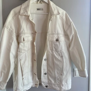 Vit oversized jacka från Gina Tricot, storlek M/L - Vit jacka med bruna sömmar, perfekt oversized på mig som vanligtvis har 36/38. Använd men väldigt fint skick!