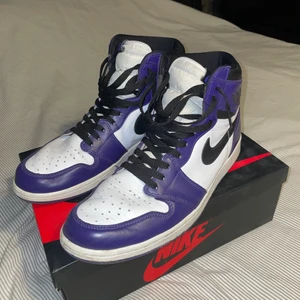 Jordan 1 Court Purple  - Säljer nu mina court purples då jag helt enkelt inte gillar de lika mycket längre och vill ha nya skor. De är köpta för ca 1 år sedan och är varsamt bärda. Jag har använt dom men inte mycket alls. Låda medgår i nyskick samt de andra skosnören man får med skorna. Cond: 8/10 Storlek: EU46. NI STÅR FÖR FRAKT!