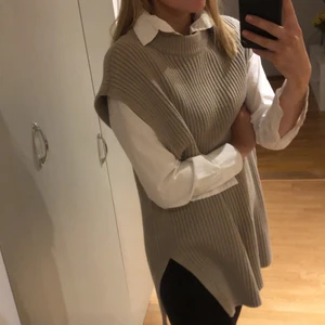 H&M väst - Mjuk lite längre väst från HM i strl S. Beige i färgen. Passar bra att både klä upp med Jeans och Skjorta eller klä ned med tights och långärmad tröja. 60% bomull 40% akryl. Använd men varsamt, inget att anmärka på.