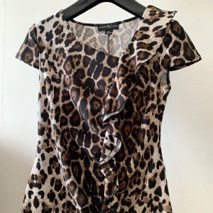 Topp - En kortärmad topp i leopard mönster med fin detalj