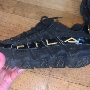 Fila black kids size 36 - Black and gold Fila . Sneakers size 36.Worn but good condition. 