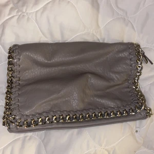 Grå clutch i skinnimiation - Grå clutch i skinnimitation. Köpt på Scorett. Det går att sätta på axelband (se bild 2)