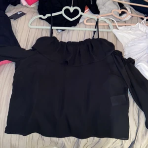 Svart topp - Aldrig använd svart tröja från Gina tricot. Långärmad men öppen på axlarna. Nypris 249, säljer för 100. Kan användas på fest och i vardagen. Möts upp i linköping eller postas men då står köparen för frakt. Storlek 38 men passar även 36
