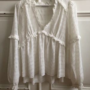 Blus - Superfin vit blus från NAKD! Blusen har detaljer i form av volanger. Tyget är något genomskinlig. Sparsamt använd! 💕
