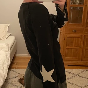 Hunkydory tröja med stjärnor  - Sååå fin tröja från hunkydory med stjärnor på armbågarna. Tröjan är svart med vita stjärnor. Silvrig dragkedja framtill och i ärmsluten. Storlek S. Skriv för fler bilder🌸 inköpt för 1000kr
