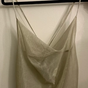 Linne stl s  - Linne med vattenfalls urringning och banden är korsade i ryggen. Materialet är see through och skimrigt. Använd 1 gång. 