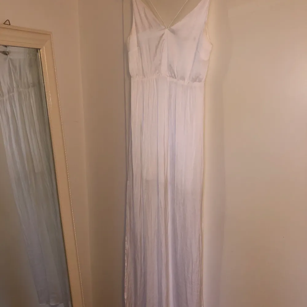 Lång vit klänning, går ner till marken på mig som är 164 cm. Endast använd en gång. Inköpt för 299 kr. Klänningar.