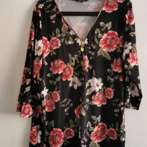 Blommig top Happy Holly strlk 48 - Blommig top från Happy Holly. Stretchigt material med dragkedja i urringningen. Storlek 48. 30kr.