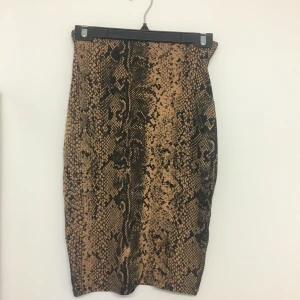 Ormönstrad kjol  - Ormönstrad kjol. Säljer tillhörande topp. Aldrig använd.