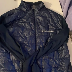 Peak performance jacka - En tunn peak performance jacka i storlek L. Den är välanvänd och har ett hål kragen och under armen, därav det låga priset.