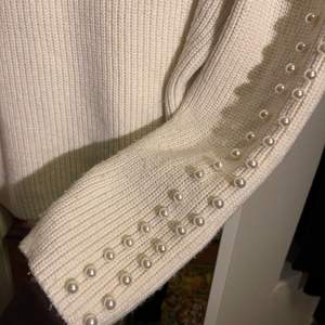 En supermysig vit stickad tröja från hm med vita pärlor längst med ärmarna. Använt ett par fåtal gånger så tröjan är alltså i bra skick. Har använt den till en vit/svart skjorta under vilket är supersnyggt!! Storleken är S
