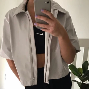 Skjorta i läderimitation från Monki - Säljer min grå/beige skjorta från Monki som är i läderimitation, as cool! Knappt använd så den är i bra skick😇