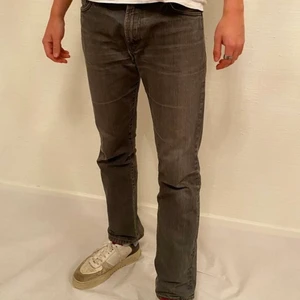 J. Lindeberg Jeans - Snygga mörkgrå jeans från J. Lindeberg.⚡️ Hade ett litet hål i en av sömmarna vid inköp som vi lagat, syns knappt men bild finns vid begäran. Storlek: W34 L32  Mått: innerbenslängd 78cm, midjemått 88cm.  Pris: 140 Modellen är 186cm lång.