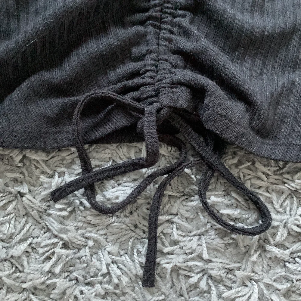 En svart ribbad tröja ifrån shein. Den har ett band som går att knyta och man kan dra så att den blir kort eller lång, Inte bästa kvaliten, men lite vad man får föreställa sig när det är från shein.. Tröjor & Koftor.