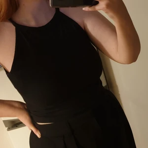 Svart linne i strl S - Svart, lite croppat linne i ribbat material. Den är i storlek S men kan nog även passa en M 😊