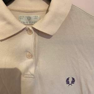 Ljusrosa Fred Perry Polo i storlek 38. Fint skick men finns ett litet hål där bak på tröjan (se foto).