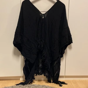Poncho med broderier - Svart poncho med broderier, passar perfekt att ha över en bikini😊