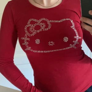 Hello kitty tröja - Skit snygg mörkröd hello kitty tröja köpt för länge sedan. Bra skick då alla kristaller sitter kvar! Endast är ett litet hål på armen (se bild 2). Men hur lätt som helst att sy ihop! Barnstorlek (146/152) men passar S och XS! Köparen står för frakt. ❤️🥰