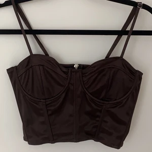 Hm topp - Knappt använd brun glansig topp från hm divided. Storlek 38 men är liten i storleken så passar bättre på nån som har xs/s. Köparen står för frakt ;) 
