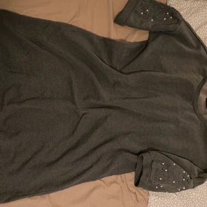 Mörkgrå tunika - Mörkgrå tunika med pärlor på ärmarna. XXXL, men man kan ha skärp i midjan så passar den som klänning/tunika till mig som är S/M. Oanvänd, bud från 40;- och bjuder på frakten 🥰🥰