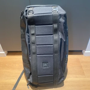 Douchebag väska  - DB väska köpt 2017 och använd på en resa. Modellen heter the carry all 65L black. Den är så fint skick och har förvarats i orginal påsen jag fick den i. Massa fack uppe, nere och störst öppnar man bak mot ryggen. 