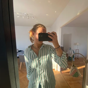Grön och vit randig skjorta - Så härlig skjorta att ha på sommaren eller under en stickad tröja nu när det är kallt, jag hade matchat den med ett par jeans, ett par jeans shorts eller en jeans kjol, den framhäver verkligen ens solbränna, använt ungefär 5 gånger, kan även leverera men köparen står för frakten💕💕