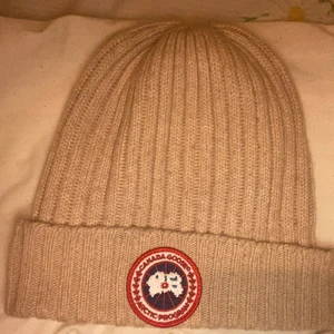 Canada Goose Mössa - Äkta beige canada goose mössa. Knappt använd då jag fick den i present, provad några gånger men insåg att jag inte passar i mössa🙃 Pris kan diskuteras vid snabb affär. 