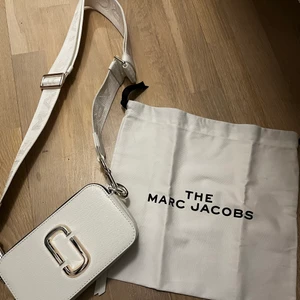 Marc Jacobs axelväska vit - Axelväska från Marc Jacobs inköpt 2019 för ca 4000kr på Jackie. Nyskick - Aldrig använd. Tygpåsen från när väskan köptes medföljes. 