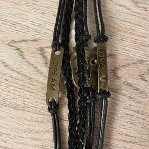 Armband svart - Säljer detta svarta, brons aktiga armbanden. Det finns sex st❤️Det är en bronsfärgad Uggla, en liten bronsfärgad bricka som det står ”love” på och en till liten bronsfärgad bricka det står ”dream”❤️Justerbara❤️Fått från min faster, ingen av oss har använt dem❤️Frakt 13kr för en, det går köpa fler❤️10kr st❤️Alla för 40kr❤️Ställ gärna frågor😃❤️Jag säljer liknande armband också❤️