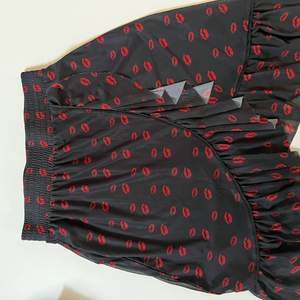Svart kjol med röda ”pussmunnar” från NAKD. Aldrig använd. Storlek s 