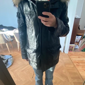 Svart jacka med pälskrage  - Så cool svart lackad jacka med pälskrage och röd/svart rutig inuti, den är köpt från prêt-a-porter men märket är SAM New York, den köptes för 6945 kr men säljer för 900 kr, det går bra med leverans men köparen står för frakten❤️