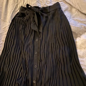 Svart kjol - Veckad midikjol i strl xs