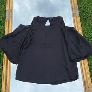 Svart blus från Gina  - Svart blus från Gina! Cutouts på axlarna. Storlek 34 men passar även 36! Köp flera plagg och få paketpris❣️