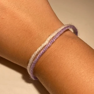 Vit och lila armband  - Vit och lila armband gjord av garn! Man får knyta den själv.