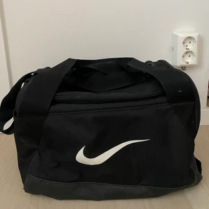 Nike träningsväska small  - Den klassiska Nike-dufflebag motsvarande deras strlk small (men väldigt rymlig). Försiktigt använd - i väldigt fint skick! Mått ca 38x23x21. 