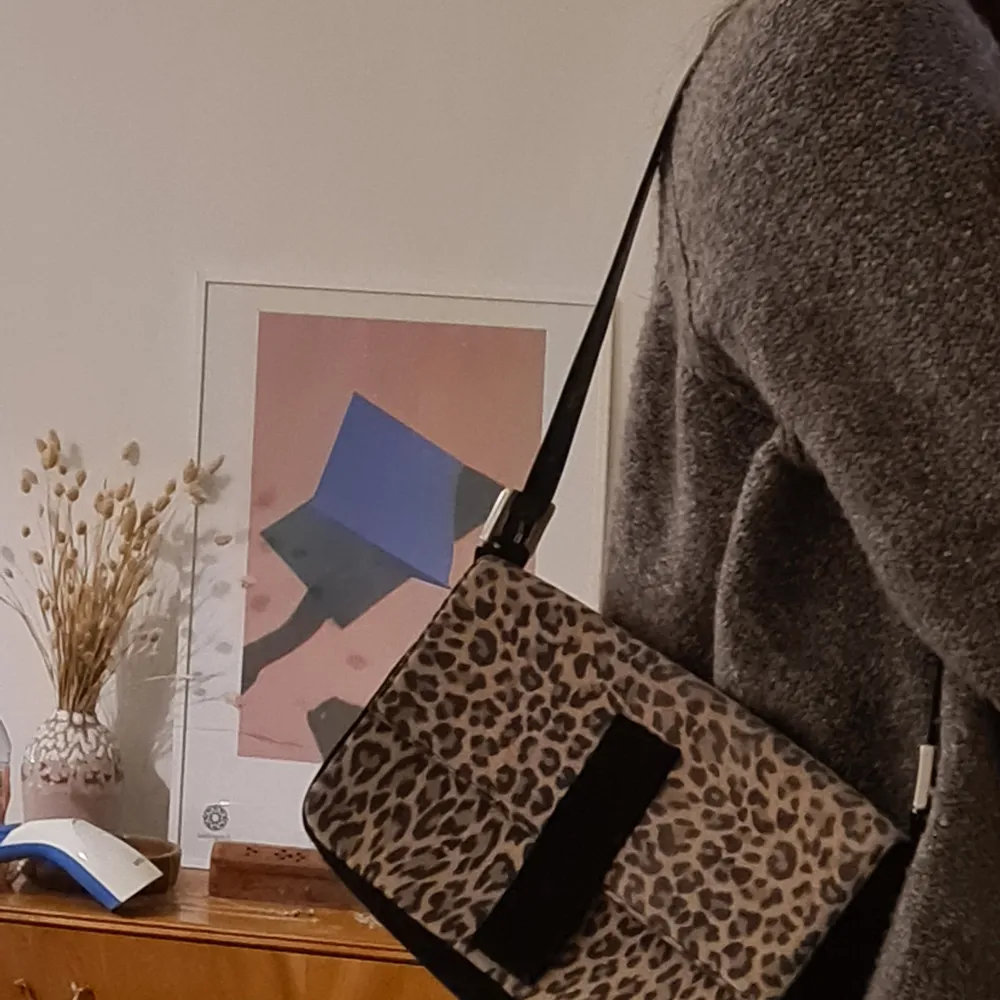 Liten handväska i leopard att slänga över axeln. Perfekt size då den rymmer the essentials. Perfekt väska att göra en outfit lite roligare med, men går ändå med det mesta. Baksidan är svart. Köpt second hand.. Väskor.