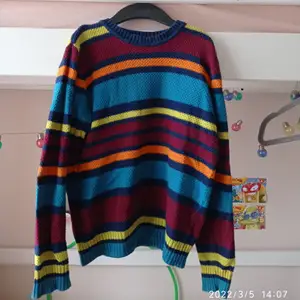 En stickad tröja med färgglada ränder. Är egentligen en tröja frö barn, men passar även ungdomar.(kontakta mig för frakt pris).
