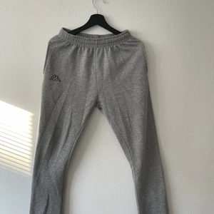 Gråa raka mjukisbyxor från Kappa - Ett par gråa mjukisbyxor som är raka hela vägen och i storlek S för herr. Priset är 150 kr!