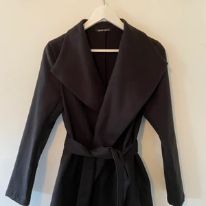 Svart kappa - Helt ny kappa från SHEIN som endast är testad. Den är i väldigt bra skick och ett bra och hållbart material. Enda nackdelen är att bandet man knyter inte sitter fast i jackan. Men sånt går att lösa med säkerhetsnål eller att sy. Säljer pga den är för liten i armarna. Säljer för 100kr och frakt tillkommer❤️