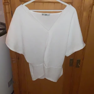 Blus från Zara - Vit blus från Zara strl S. Knytning i fram och V-ringning.