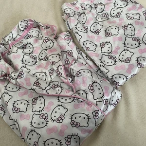 Hello Kitty pyjamas set i siden - Fint hello Kitty pyjamas i siden. Setet är i fint begagnat skick bara att en av knapparna sitter lite löst på skjortan. Det är i barnstorlek 158/164. Bud från 129 kr 💞🐱  Ni får välja om ni vill ha spårbar frakt som är lite dyrare eller billigare frakt utan spårning.