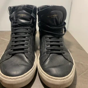 High-top Givenchy sneakers  - High top givenchy sneakers i svart läder och vita detaljer. Skorna är använda men har blivit väl omhändertagna över det senaste året. Sulan är lite sliten inuti skon men utöver det är produkten felfri. Tvättas innan spårar frakt. Nypris 6000kr