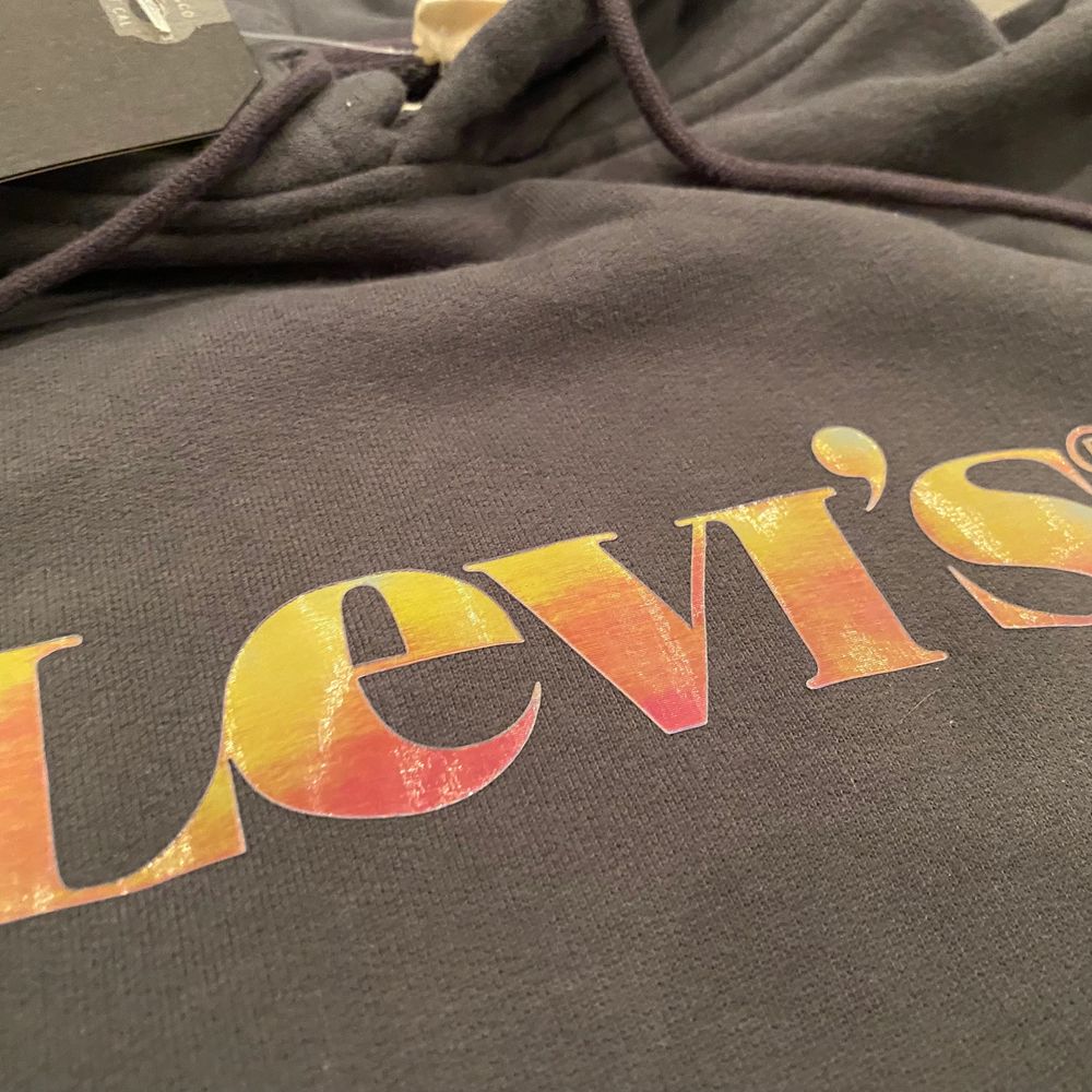 En Levis hoodie med loggan graphic och den är i färgen mörkgrå. Färgen skiftar i olika färger. Aldrig använd. Inget tecken på användning och taggen sitter kvar. Storlek M. Kan skicka mer bilder i DM. Köparen står för frakt 🚚 . Huvtröjor & Träningströjor.