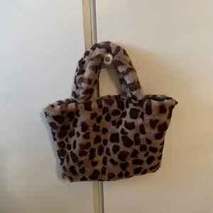 Fluffig väska i leopardmönster, använd typ 1 gång så därav i orginalskick. 