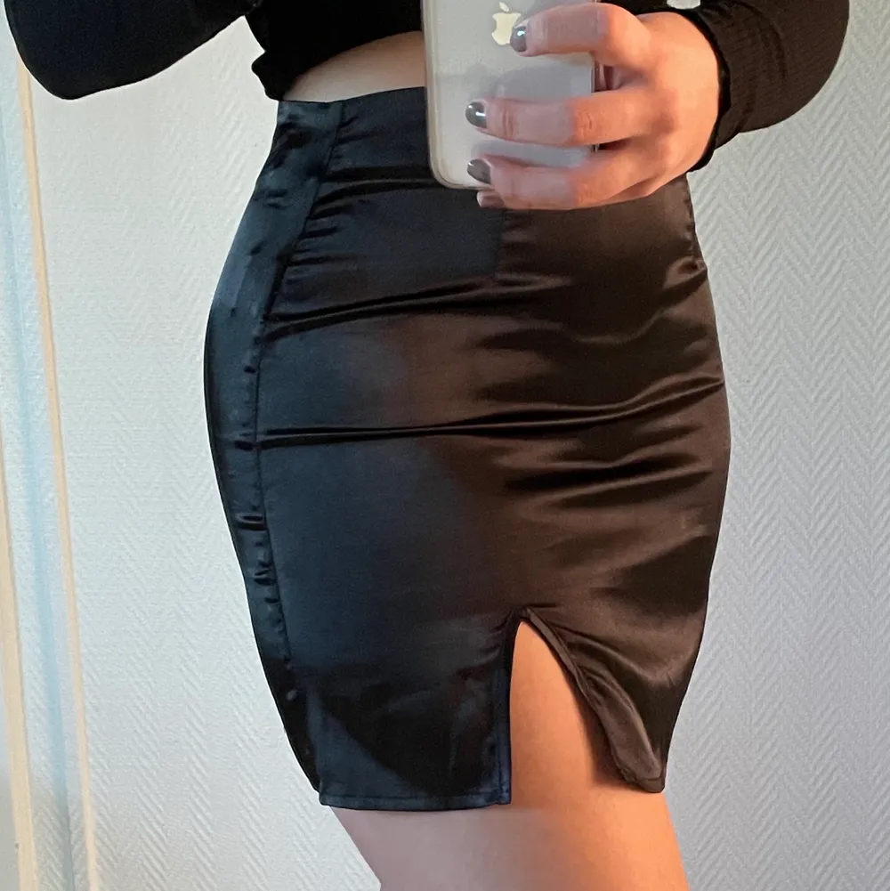 Trendig svart kjol i satin, säljer pga att den är för liten för mig🥺 Har dragkedja i sidan och en liten slits över vänster ben. Jag är 172 cm. Köparen står för frakten🤎. Kjolar.
