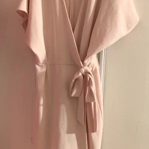 Ljusrosa omlottklänning  - Underbar ljusrosa omlottklänning. Perfekt för middagar, bröllop eller en vanlig sommardag! 