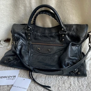 Balenciaga City Väska - Svart Balenciaga City Medium Bag. Kommer med axelband, spegel, kort samt äkthetsbevis. Superbra skick! Mått: 38x26x14 cm. Jag postar spårbart med Postnord. Skriv gärna för fler bilder eller om du har några funderingar :)