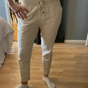 Beiga linnebyxor  - Beiga linnebyxor med resor och snöre i midjan. 